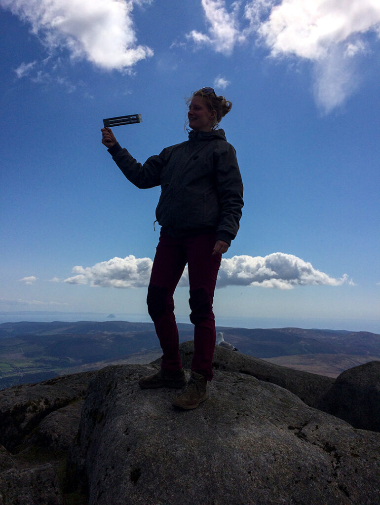 Florentine stands on top of a mountain displaying one of the tools she uses to measure atmospheric drying. 