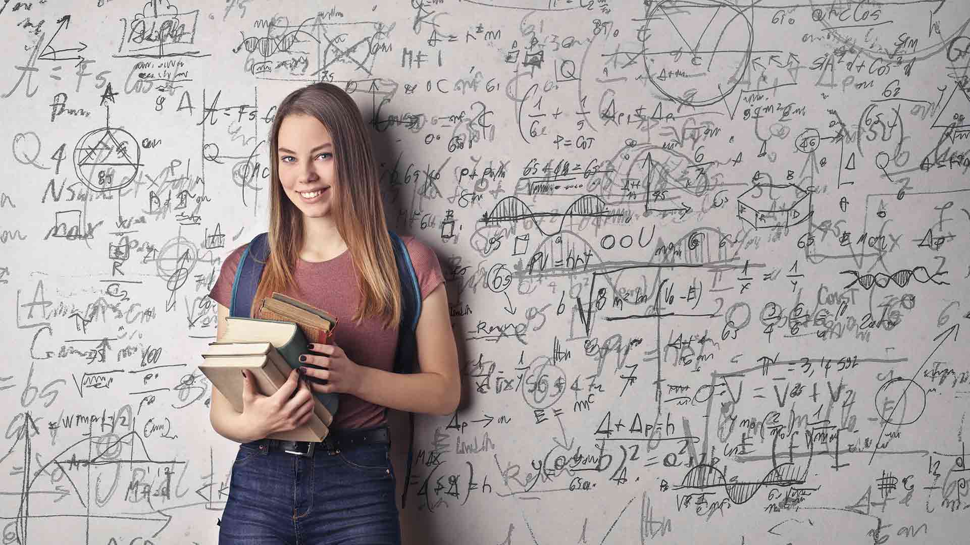 keep it complex? Woman with books in front of white board full of confusing looking maths