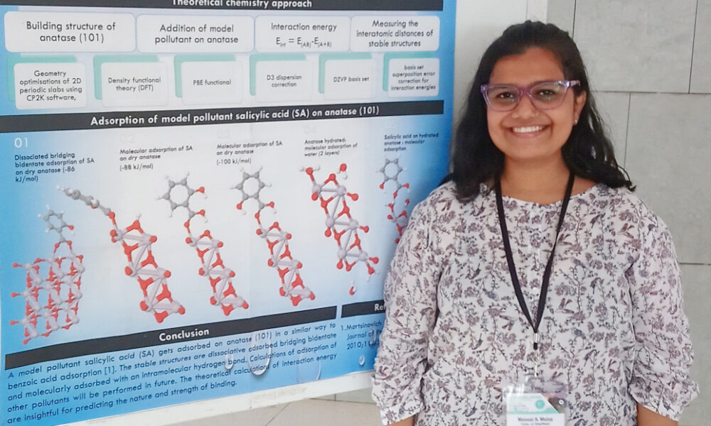 Manasi Mulay stands in front of a poster which explains how to use chemistry to treat water micropollutants.
