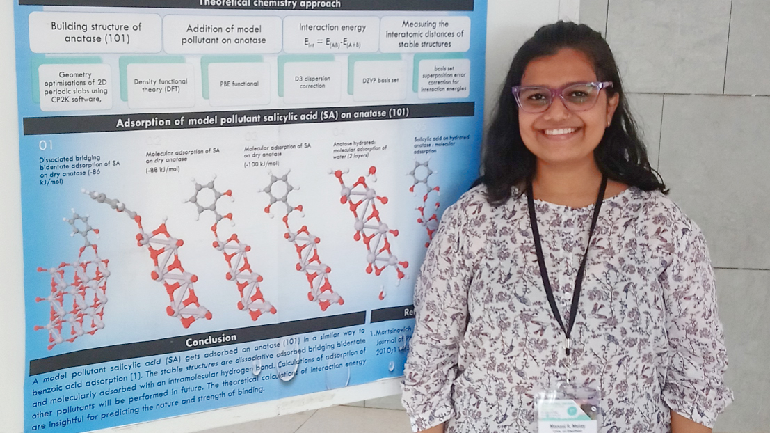 Manasi Mulay stands in front of a poster which explains how to use chemistry to treat water micropollutants.